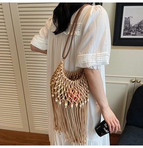 Close-up of woven hollow shoulder bag with long tassels and beads for beach vacation