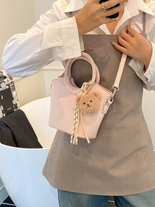 Chic pink bucket bag with plush bear charm and striped ribbon for summer fashion