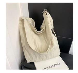 Dettaglio della borsa tote plissettata bianco sporco con trama del tessuto e fibbia