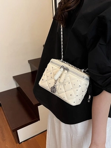 Quilted off-white box bag with crystal studs and floral charm on a leather chain strap