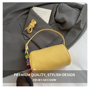 Detail of yellow pebbled leather cylindrical bag with colorful CHLOE letter charm accessory