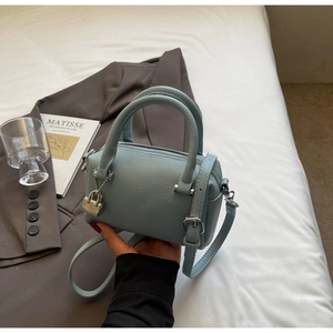 Detailed close-up of light blue pebble leather mini Boston bag with silver padlock detail