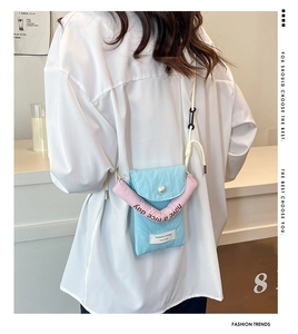 Detail of Korean-style mini crossbody bag with contrast colors and pearl buckle closure