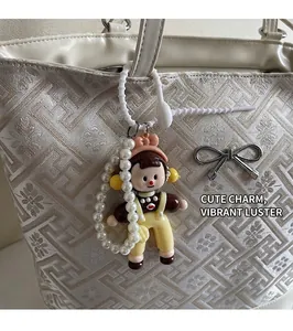 Charming cartoon doll bag charm with pearl chain on a stylish quilted tote bag
