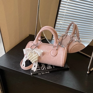 Borsa a cilindro rosa con ciondolo in pizzo e perle e tracolla regolabile