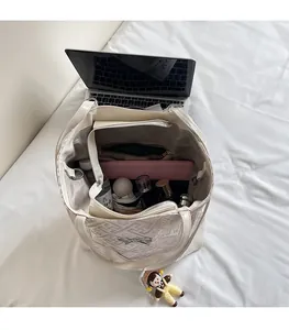 Top view of open beige quilted tote bag showing large capacity with daily essentials