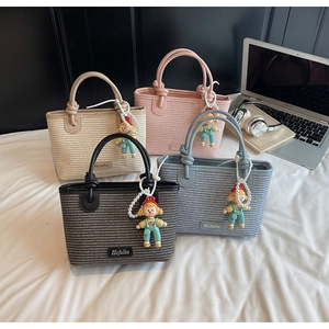 Detailed row of woven bucket bags in beige, pink, black, and blue with pearl charms