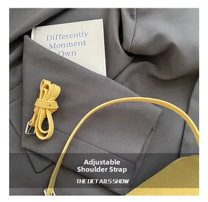 Detailed view of yellow lychee leather adjustable shoulder strap with silver metal buckle