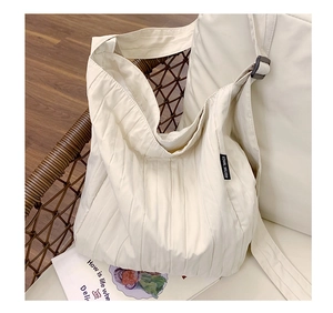 Dettaglio della borsa tote in tela pieghettata bianco sporco con tracolla regolabile