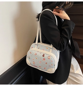 Detail of blue plaid boston bag featuring cute cartoon embroidery and white leather trim