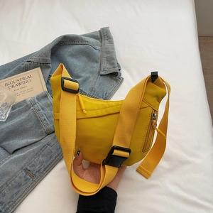 Detail of yellow waterproof nylon crossbody bag with adjustable strap and side zipper