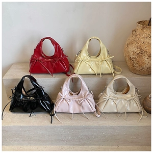 Detailed view of fashionable bow pillow bags in red, yellow, black, pink, and ivory