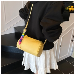 Detail of yellow lychee texture cylindrical crossbody bag with colorful bead charm