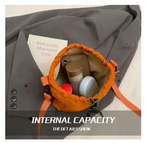 Detail of orange bucket bag interior capacity holding phone and cosmetics