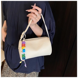 Close-up of white lychee texture cylinder bag with colorful acrylic letter charms