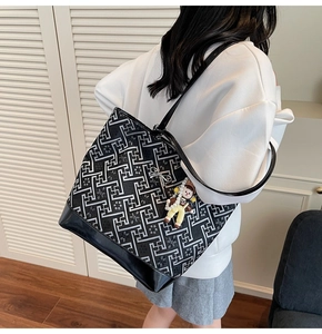 Rear view of a model wearing the large geometric pattern tote bag with glossy base