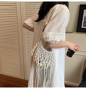 Detail of hand-woven white mesh bag with multi-color wood beads and long fringes