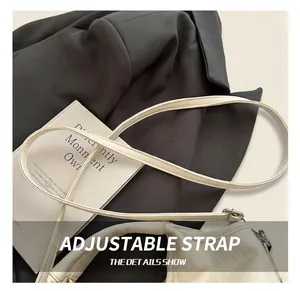 Detail showing the adjustable shoulder strap and silver metal hardware on cream tote bag