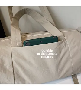 Detail view of the durable side pocket on the beige travel bag holding a tablet