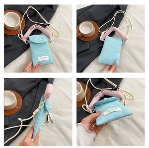 Detail view showing light blue nylon phone bag with pink handle and pearl button closure
