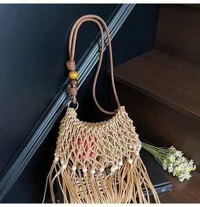Close-up of khaki woven bag featuring fringe tassels and beaded leather shoulder strap