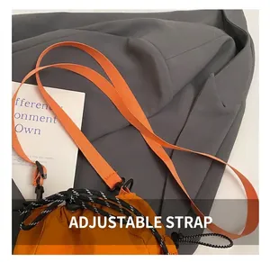 Detail of adjustable woven shoulder strap on vibrant orange nylon bucket bag
