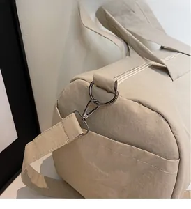 Close-up of waterproof nylon travel bag with silver metal ring buckle and zip detail