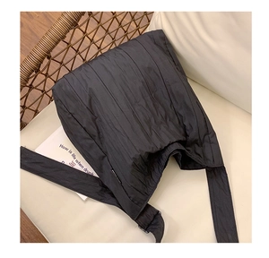 Dettaglio macro del tessuto in nylon a pieghe nere e dell'etichetta laterale della borsa