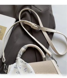 Detail of contrast stitching beige bag with woven texture and silk scarf handle