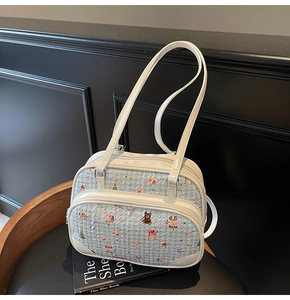 Detail of light blue waffle fabric handbag with cute cartoon bear prints and white leather straps