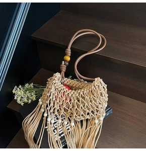 Detailed shot of woven bohemian tassel bag with colorful beads on wooden stairs