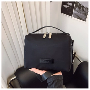 Détail du sac boîte noir en nylon avec double fermeture éclair et poignée supérieure
