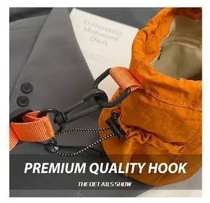 Detail of bright orange drawstring bucket bag featuring durable plastic hooks and woven straps