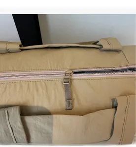 Detailed close-up of smooth khaki metal zipper and durable nylon fabric on travel bag