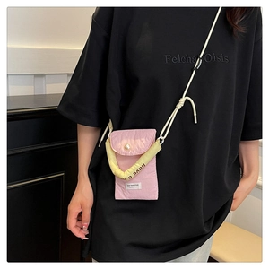 Pink crossbody phone bag with pearl button detail and braided rope strap shown on model