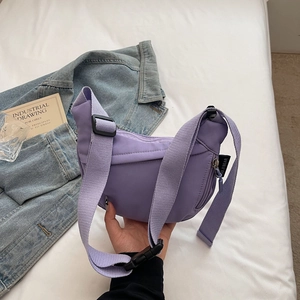 Close-up of lilac nylon crescent bag with adjustable wide strap and branded woven label