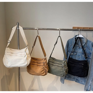 Detail of vintage washed canvas bags in four colors with multiple functional zippers