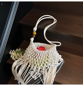 Detail of woven cotton shoulder bag with wooden beads, fringe tassels and mesh structure