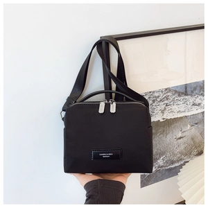 Détail du sac caméra en nylon noir avec bandoulière réglable et fermeture éclair double
