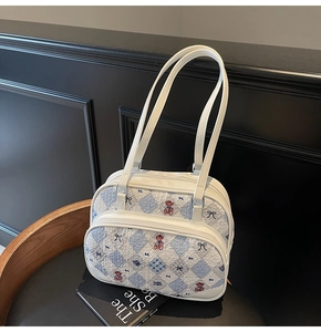 Detail of cream white bag showing blue diamond pattern and cute bear graphics