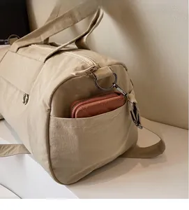 Detail view of khaki travel bag side pocket with durable nylon fabric and large capacity