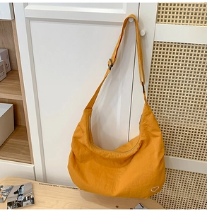 Detail of ginger yellow nylon moon bag with wrinkled texture and heart print