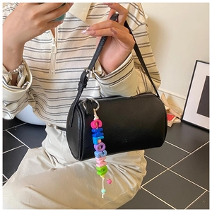 Close-up of black lychee grain leather cylinder bag with colorful Chloe charm detail