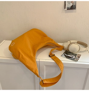 Detailed macro view of ginger yellow nylon crossbody bag with heart pattern on the side