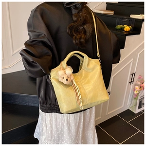 Lime yellow crocodile pattern bucket bag shown from a back view on a model
