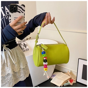 Detail of green leather pillow bag with colorful CHORUNU letter bead charm and top handle