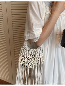 White bohemian woven hollow shoulder bag with tassels for summer beach vacation