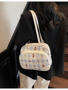 White casual underarm tote with bear pattern and dual straps shown on a model