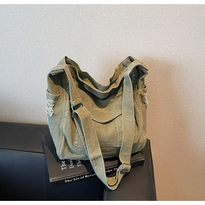 Detail showing distressed raw edges and side pockets of the army green canvas tote bag