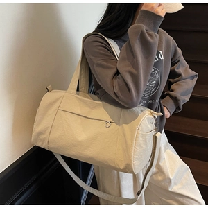Close-up of off-white travel bag with nylon texture and adjustable shoulder strap